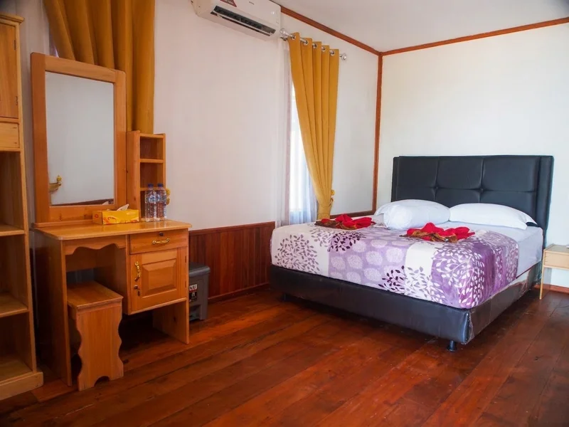 Spacious premium chalet interior with a large double bed and warm wooden paneling.