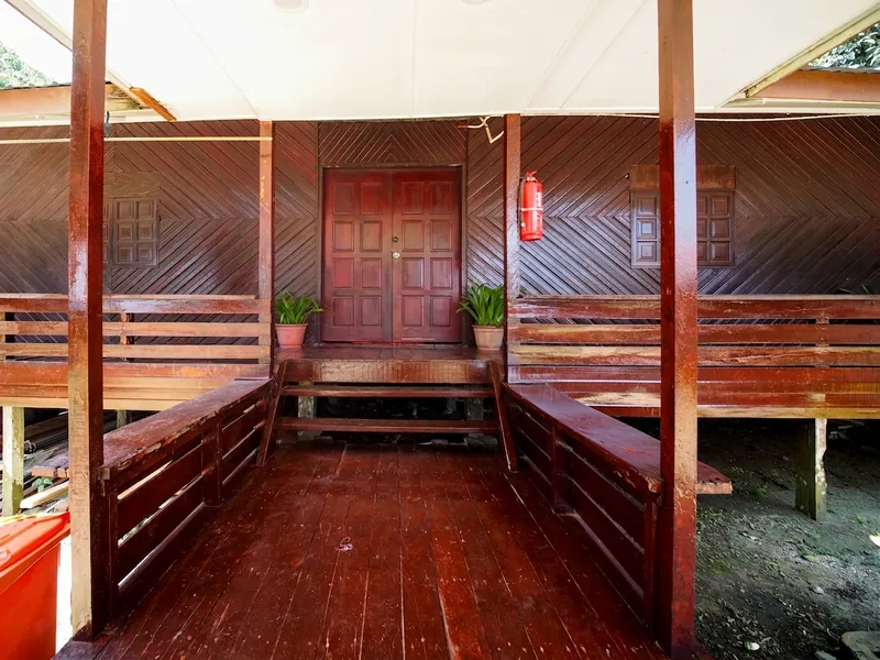 The standard room building features wide wooden decks and is located close to communal areas.