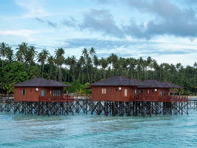 Exotic over-water villas built on stilts above the clear blue lagoon.