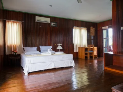 Spacious and eco-friendly Water Villa interior with a comfortable king-size bed.