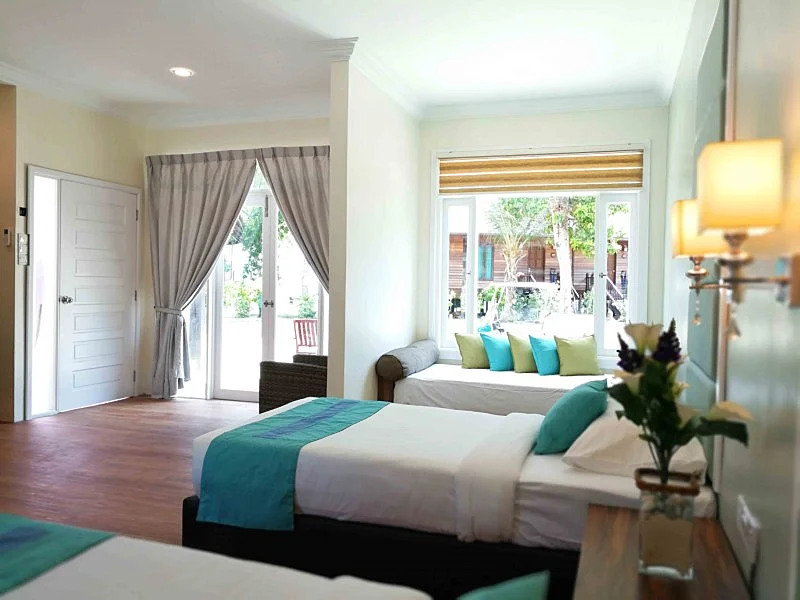 Premium room interior with traditional Malaysian charm and twin beds.