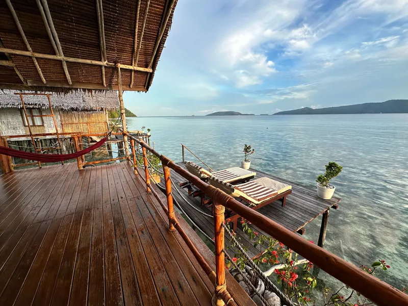 Spacious over-water balcony with a hammock and panoramic sea views.