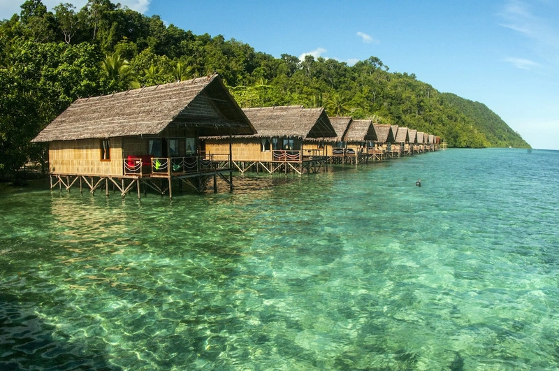 Traditional stilt architecture of the Deluxe bungalows over the turquoise waters.