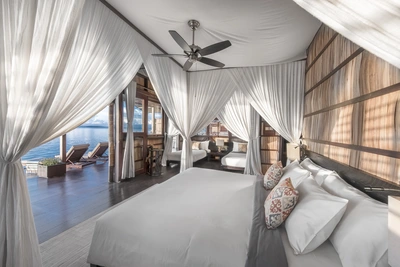 Elegant Deluxe bungalow interior with teak wood furniture and natural lighting.