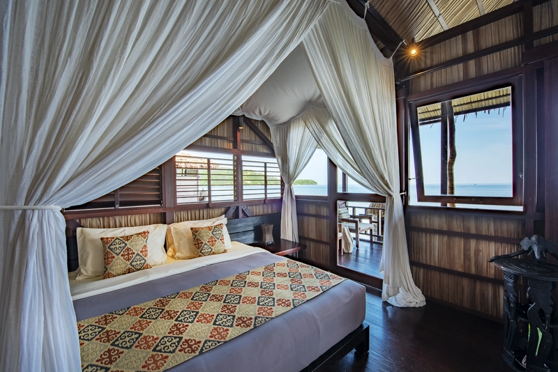 Modern comforts and traditional Papuan Asmat artwork in the Deluxe room.