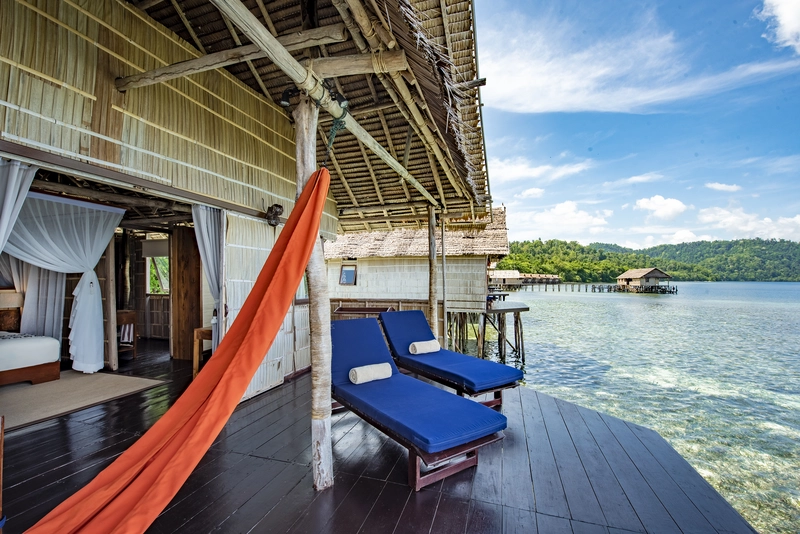Large sunset veranda of the Superior bungalow with sunbeds and sea views.