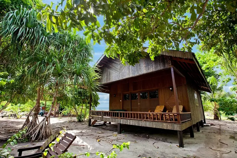 Traditional wooden villa exterior nestled in a quiet garden setting.