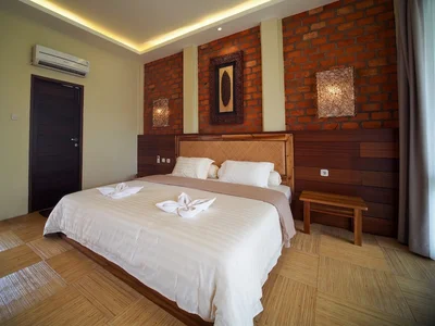 Elegant Sidau Cottage interior featuring warm wooden tones and a comfortable queen bed.