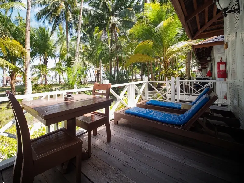 Private front balcony with comfortable seating overlooking the tropical surroundings.