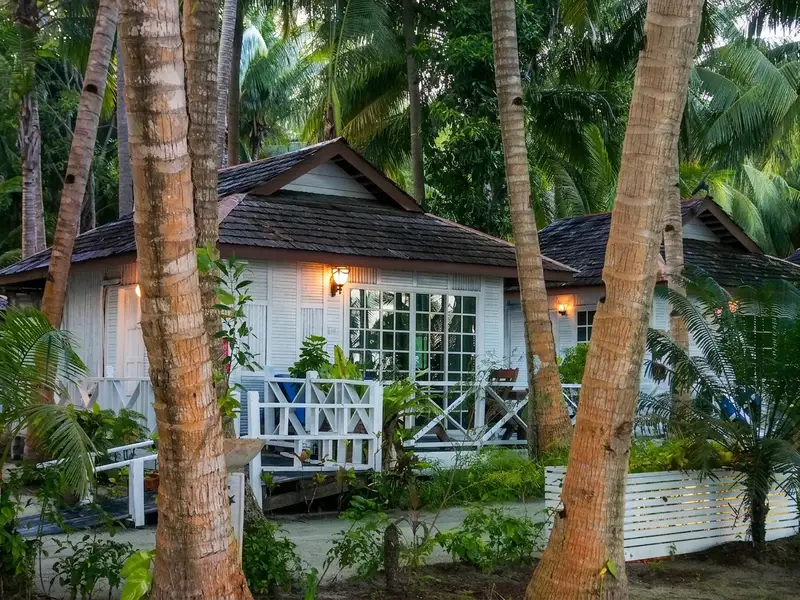 Traditional standalone chalet exterior nestled among the coconut trees.