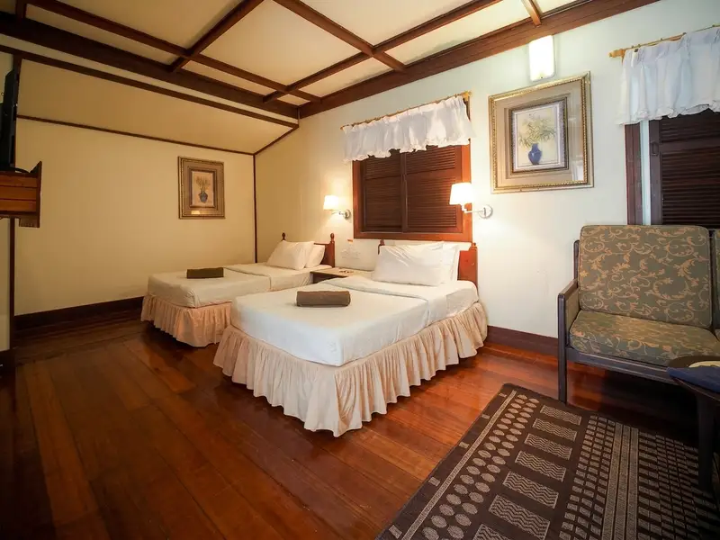 Comfortable standalone chalet interior featuring native Borneo timber and oversized beds.