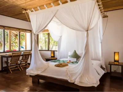 Comfortable king-size bed in the Sentani Cottage.