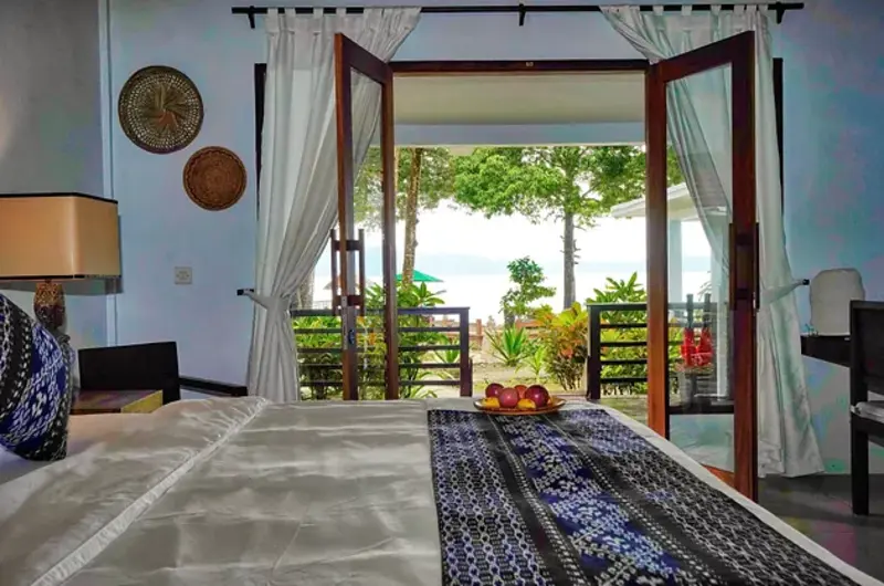 Spacious master bedroom in the Seafront Villa, designed for relaxation with sea views.