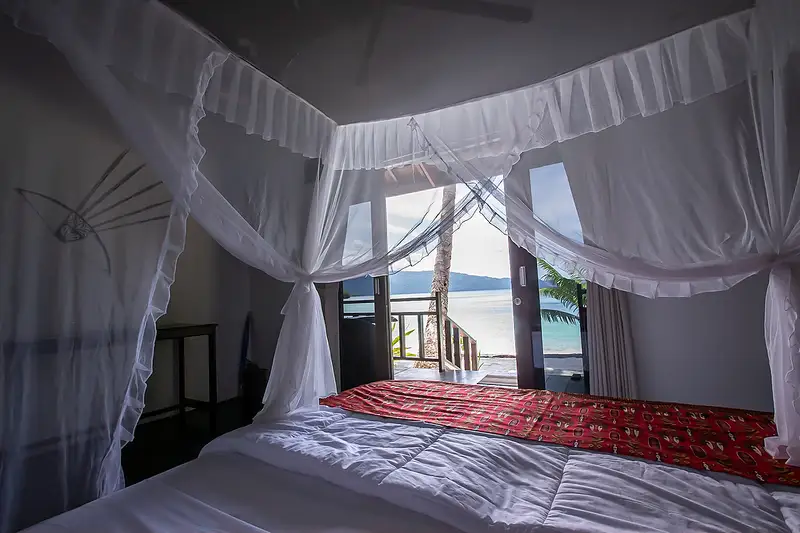 Spacious bedroom area with a king-size bed and natural ventilation.
