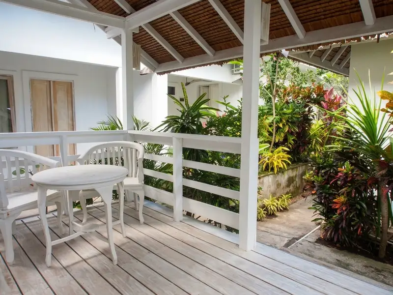 Traditional eco-friendly bungalow exterior surrounded by tropical greenery.